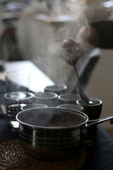 Pouring homemade hot black coffe from large metal pot. Selective focus.