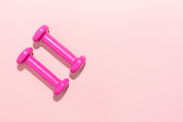 Dumbbells flat lay on pink background