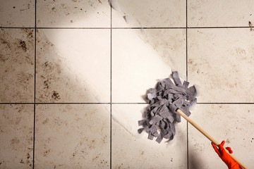 Woman cleaning tile floor with mop, top view. Space for text