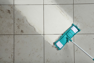 Cleaning tile floor with mop, top view. Space for text