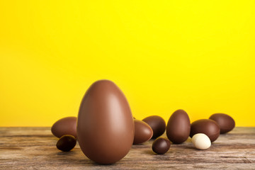 Beautiful composition with chocolate Easter eggs on wooden table