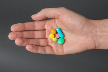 Woman holding weight loss pills on gray background, closeup