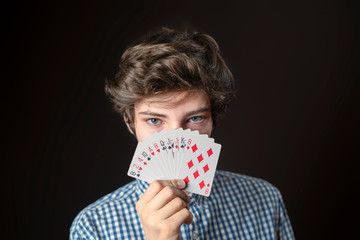 closeup portrait of teen male hold gambling card show it and cover face b