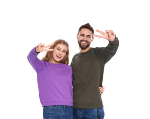 Fototapeta premium Happy young people showing victory gesture on white background