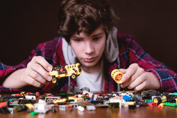 young male construct toy bricks on wooden table child toy childhood b