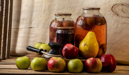 Home-made canned compote and fresh fruit on the basement shelf still life