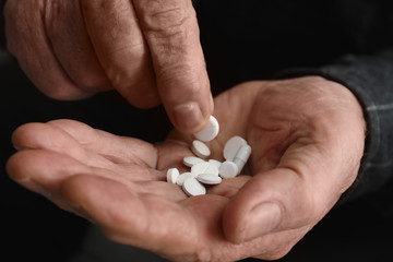 Senior man taking pills, closeup of hands