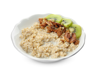 Bowl of quinoa porridge with walnuts, kiwi and milk on white background