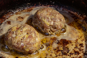 Fresh meat cutlets in a frying pan grill.