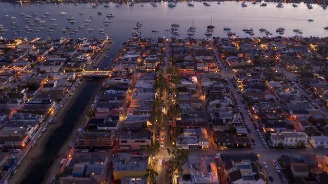 Aerial time lapse in motion or hyperlapse over a bridge with traffic and streets showing streaks of car lights, city buildings, showing the coastal California city lifestyle.