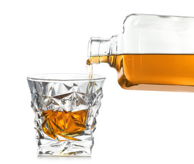 Pouring expensive whiskey into glass on white background