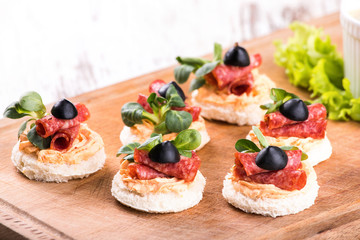 Canapes with salami and olives