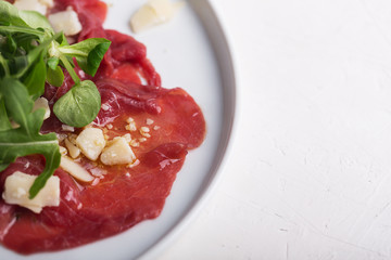 Beef carpaccio with arugula and sauce. Close up