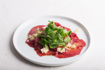 Beef carpaccio with arugula and sauce. Horizontal orientation