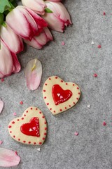 Valentines day frosted heart cookies with pink tulips background