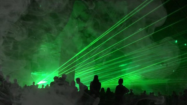 Cinemagraph - green laser rays and fog at a party. Psychedelic effect