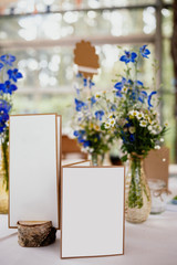 Sommerlich dekorierter Tisch auf einer Feier mit Karten auf einem Tisch mit bunten Blumen