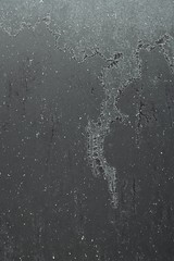 Texture of frozen dark grey metallic coloured car trunk of compact crossover car.with pattern of spilled frozen water. 