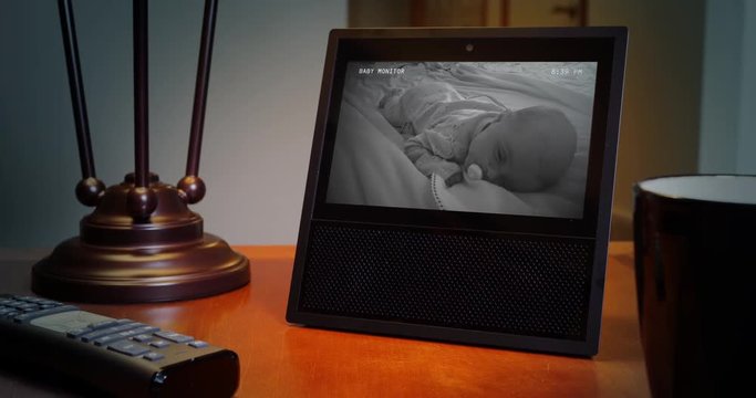 A slow push in dolly shot of a baby monitor on a home's living room end table.  	