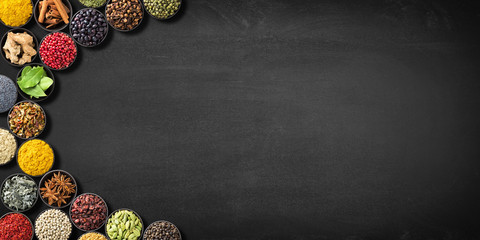 collection Indian spices and herbs on  blackboard. colorful seasonings on  black table, top view....