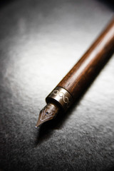Macro shot with shallow depth of field focusing on metal nib with fine iridium point and engraved...