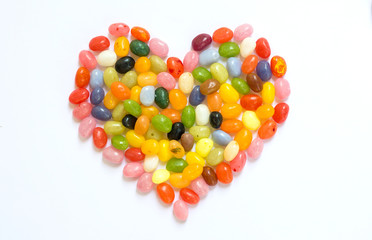 Heart made of colorful jelly beans candies isolated on white