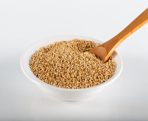 Quinoa grains with spoon and bowl on white background