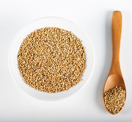 Quinoa grains with spoon and bowl on white background