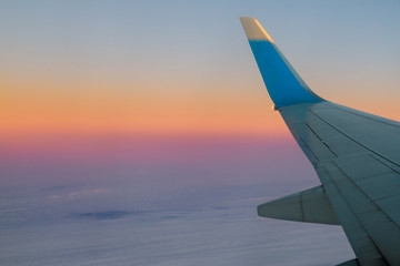 Fototapeta na wymiar Airplane in the sky at sunrise Flying in the of clouds.