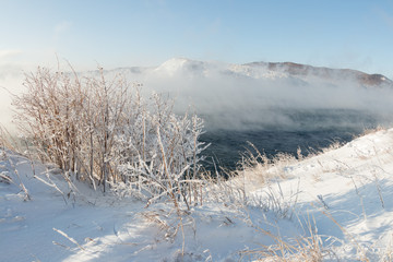 Baikal in winter is covered with water vapor by foggy steam in January