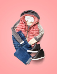 Collection of winter women clothing on pink background. Composition with jacket, jeans and shoes