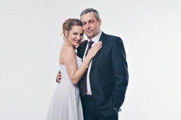 Wedding couple on the nature is hugging each other. Beautiful model girl in white dress. Man in suit. Beauty bride with groom. Female and male portrait. Woman with lace veil. Lady and guy outdoors