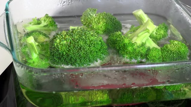 Cooking  broccoli in a glass pot on an electric stove
