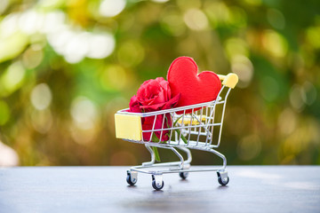 Valentines day shopping and roses flower Shopping cart full with Red Heart and rose flower for Valentines day