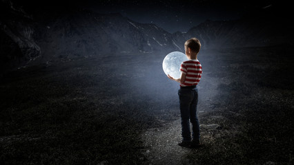 Fototapeta premium Boy holds the moon . Mixed media