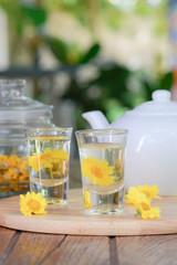 Yellow Chrysanthemum tea set with pot on wooden table for served in morning. Chinese herb for health.