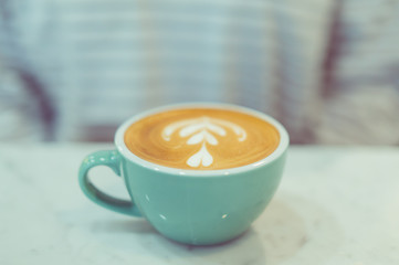 a cup of hot latte coffee with heart shape latte art, coffee lover concept, autumn color tone