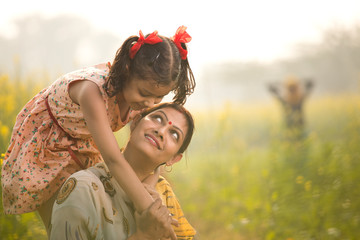Mother with daughter having fun at agriculture field