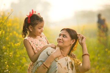 Obraz premium Mother with daughter having fun at agriculture field