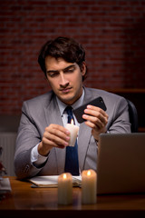 Businessman working late in office with candle light