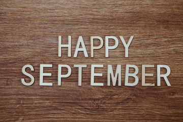 Happy September text message on wooden background