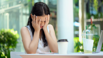 The young woman sitting with feeling stressed and frustrated