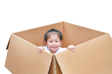 Happy little Asian child girl playing peekaboo and lie in big cardboard box.
