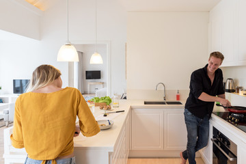 Couple cooking on a white kitchen at home