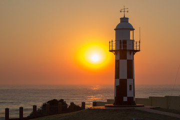 sunrise over the Indian ocean with lighthouse in the foreground 