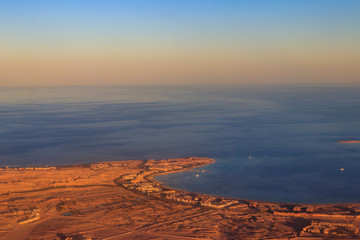 Aerial view on Red sea, Arabian desert and touristic resort near Hurghada, Egypt. View from airplane