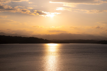 Beautiful sunset time. Glowing gold reflecting through the water surface.