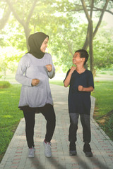 Happy little boy jogging with his mother