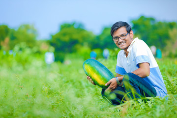 young indian farmer at watermelon field