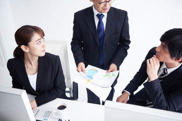 3人で１つの書類を確認し意見を交し合う風景